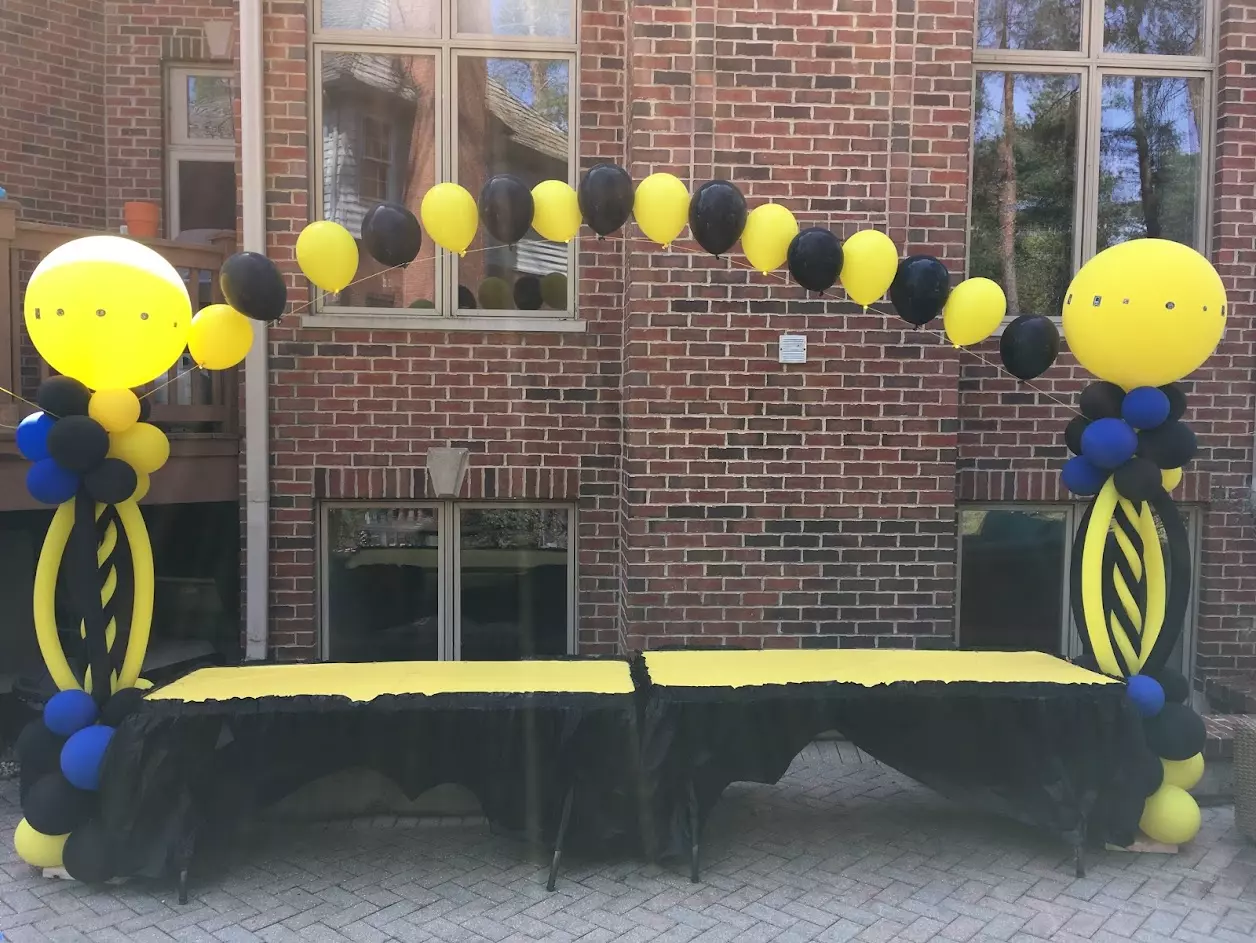 black and yellow balloon arch